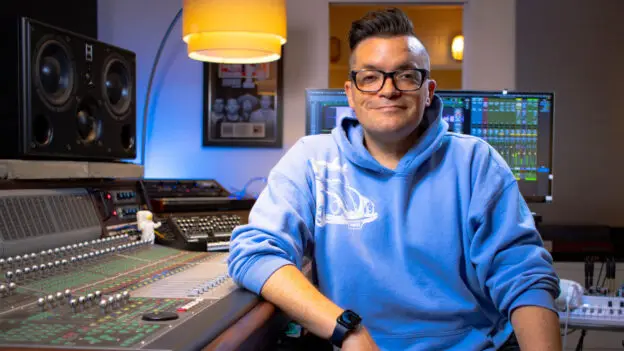 Natural Vocal Production course thumbnail with Dana Nielsen in blue hoodie leaning on recording console.