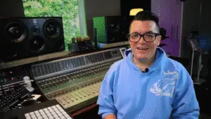 Animated GIF of Dana wearing blue hoodie, smiling, and speaking to camera in front of his recording console